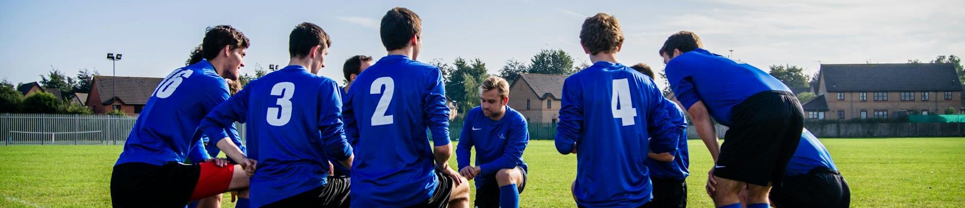 group of sports player kneeling on field
